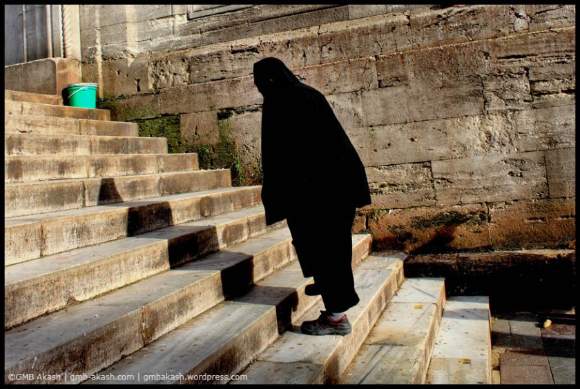A woman is stepping towards stairs of mosque